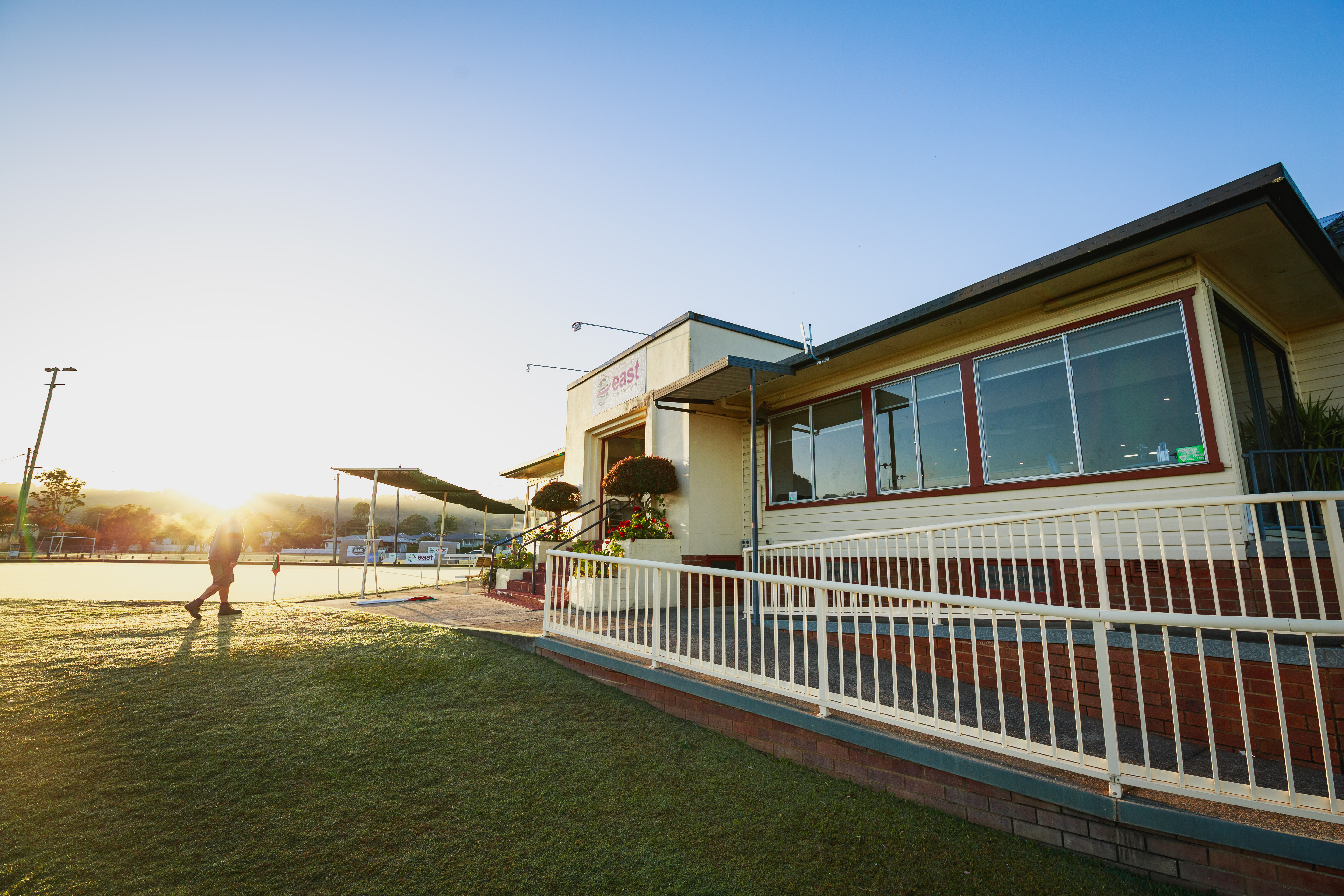The East Lismore Bowling Club clubhouse at golden hour, looking out over the green